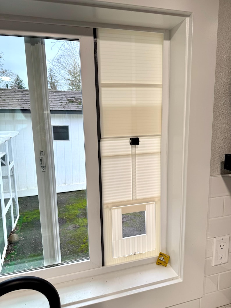 Cat door insert installed vertically in the track of a sliding window, interior view